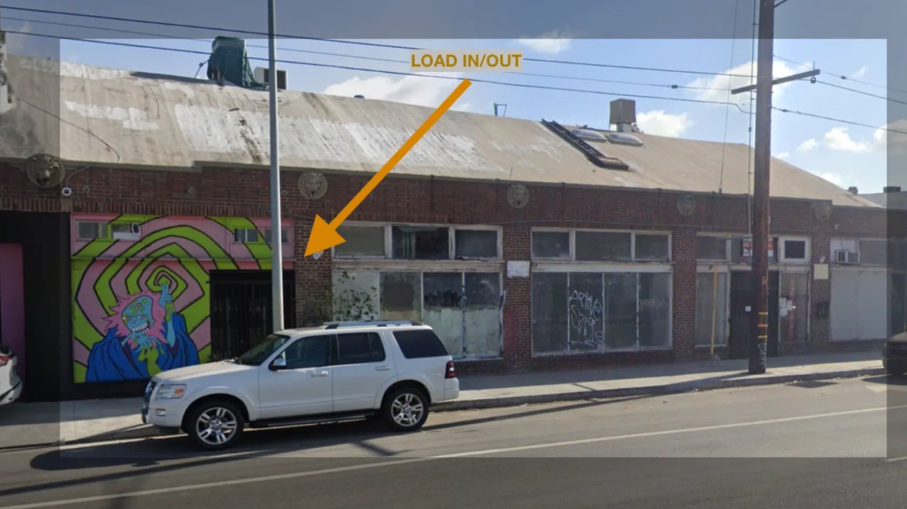 The Olympic Blvd frontage with an arrow marking the load-in entrance beside the mural